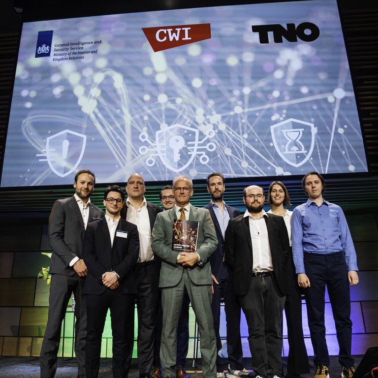 Minister of Digitalisation and Kingdom Relations Zsolt Szabó (in the middle) with members of the PQC Migration Handbook team on 3 December in Amare in The Hague. From left to right: Thomas Attema (TNO), Alessandro Amadori (TNO), Ronald Cramer (CWI and Leiden University), Vincent Dunning, Zsolt Szabó, Marc Stevens (CWI), Maxime Bombar (CWI), Simona Etinski (CWI) and Daan van Gent (CWI).