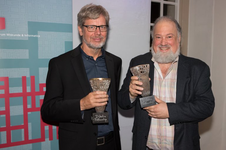 Guido van Rossum en David Chaum met de Fellowship Award in hun handen