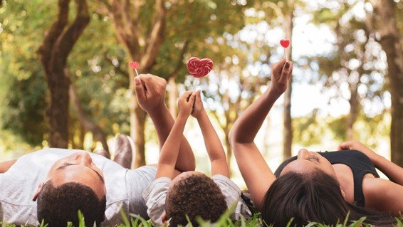 people laying in a field with heart shaped lollipops